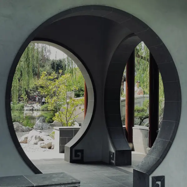 A view from a circular passageway into a Chinese garden.