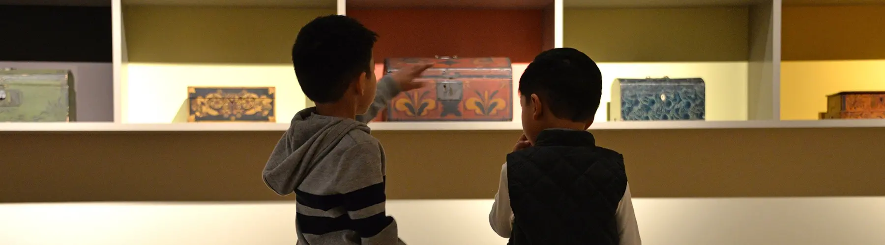 two boys looking at art boxes