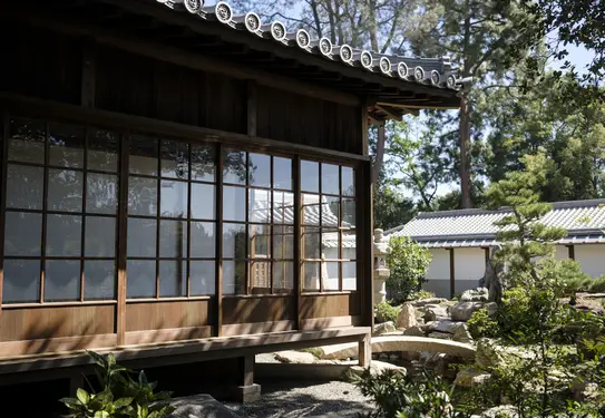 A view of a garden near a traditional Japanese home.