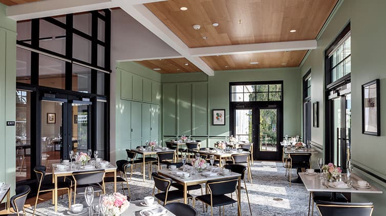 Set tables inside a glass-doored and mint-color walled room.