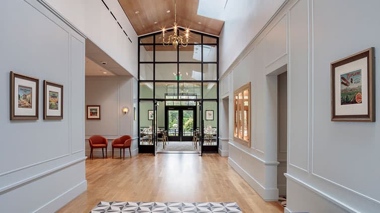 The interior foyer of a tea room with cathedral ceiling and floor-to-ceiling glass.