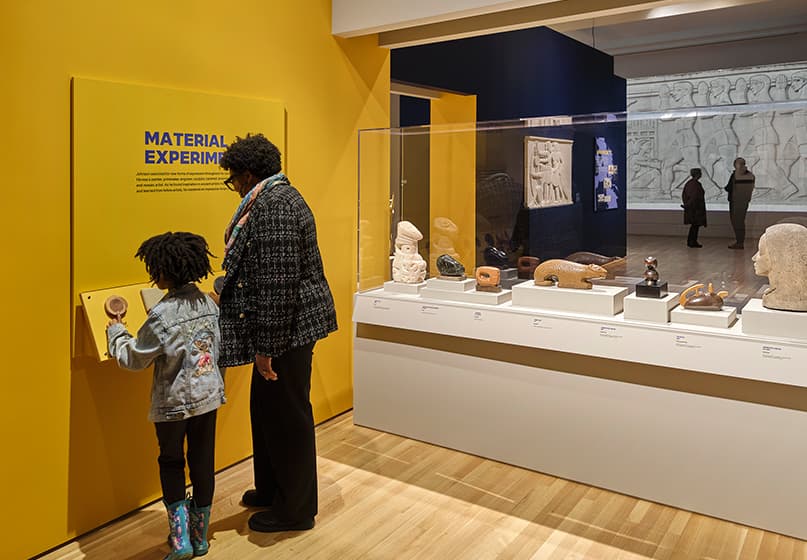 People stand in a gallery looking at artwork.