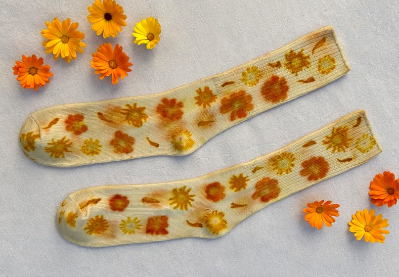 A pair of socks with a colorful pattern of flower-shapes.