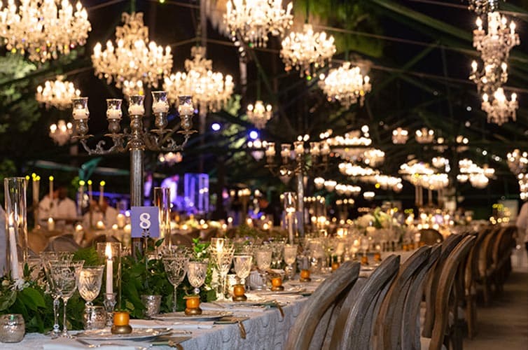 Long dining tables set up under fancy chandeliers.