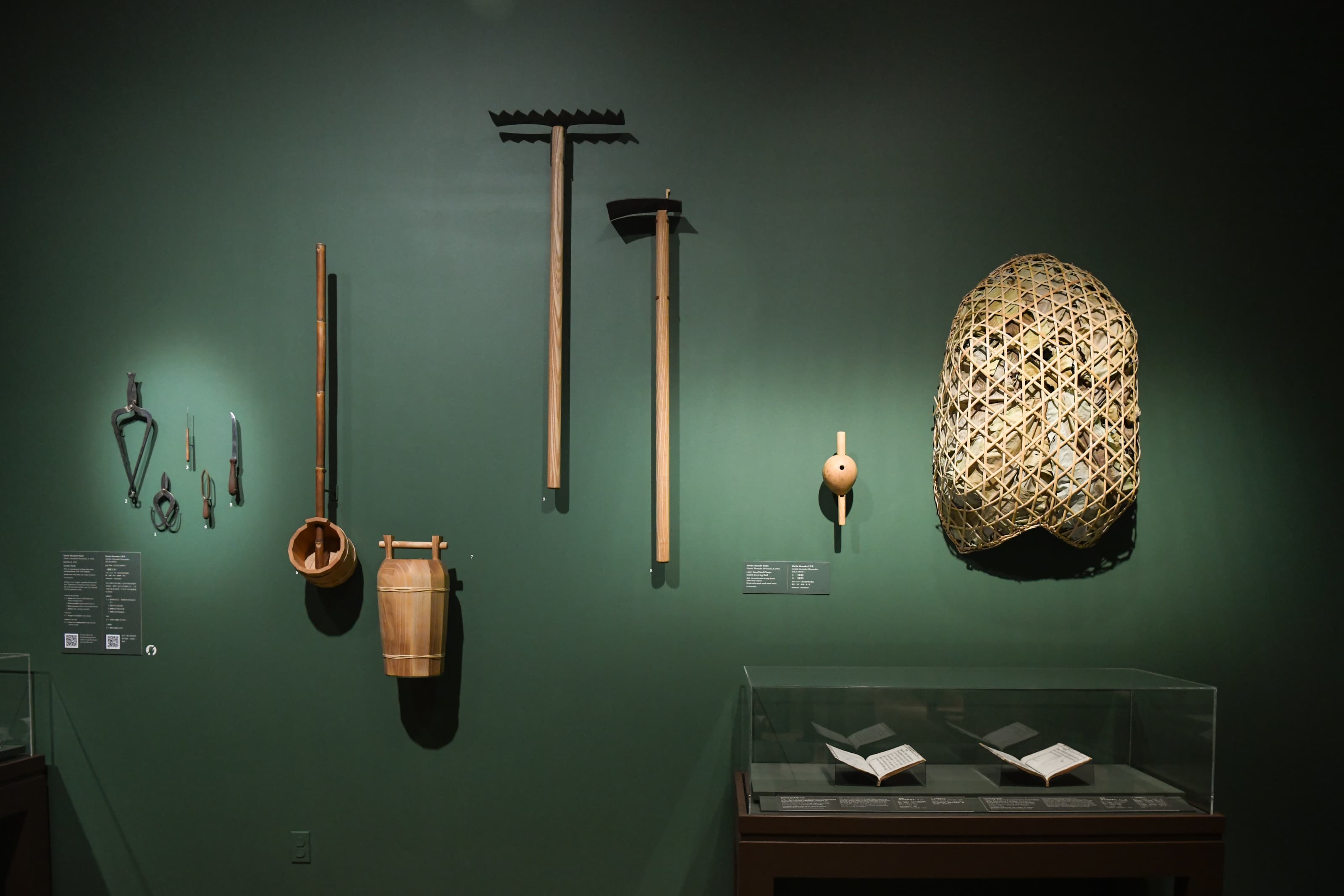 Traditional Chinese tools hang on a green wall.