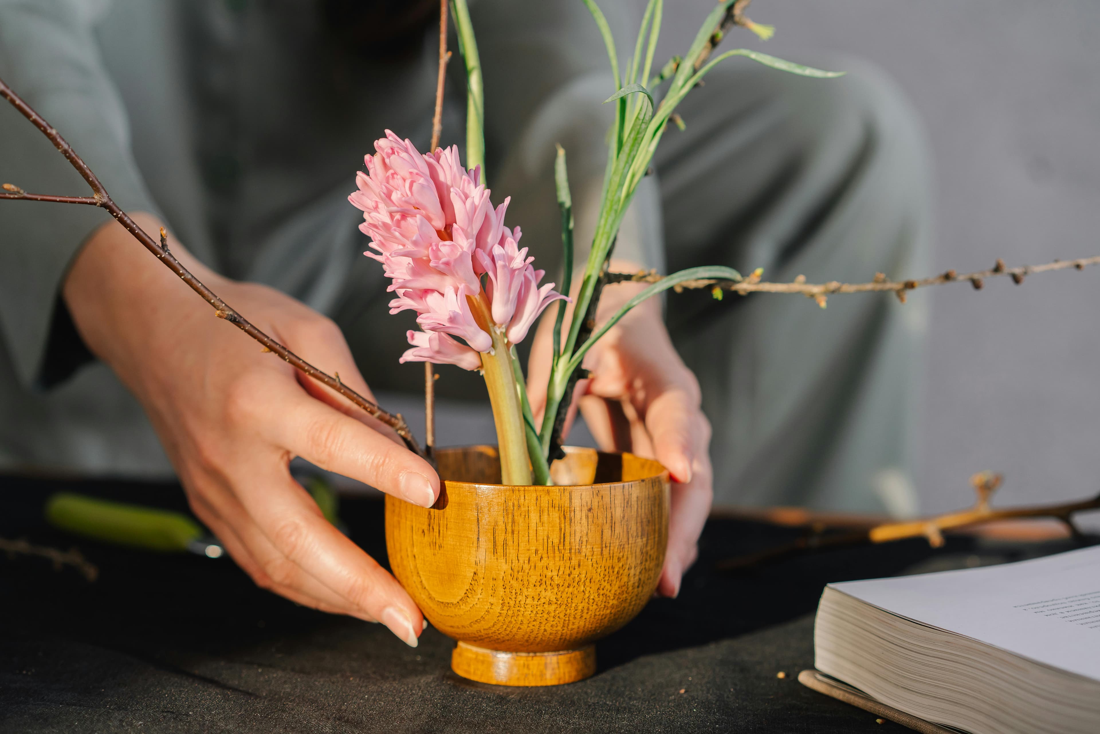 A Japanese-style floral arrangement in a wooden bowl.