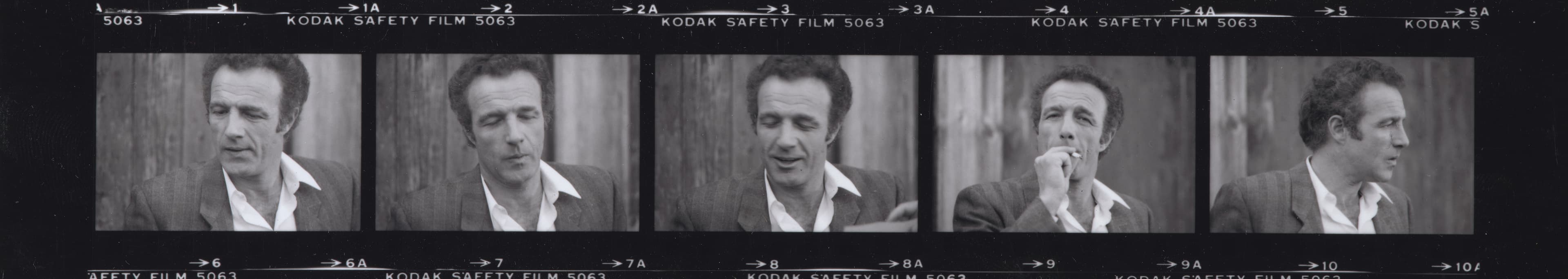 A grayscale, horizonal film strip with images of man in a gray suit jacket and a white shirt.