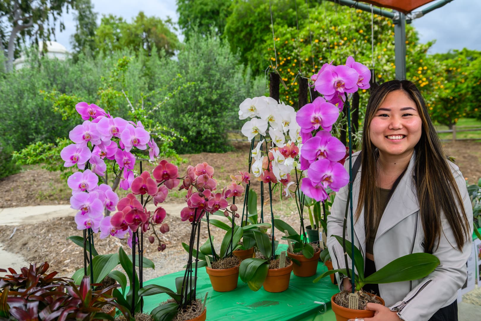 A smiling persons with blooming flowers.
