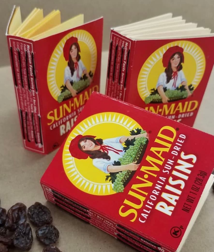 Three small books created using raisin-box packaging as the outer cover.