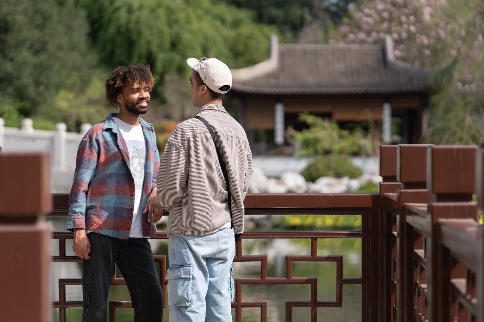 Two people have a conversation in a garden.
