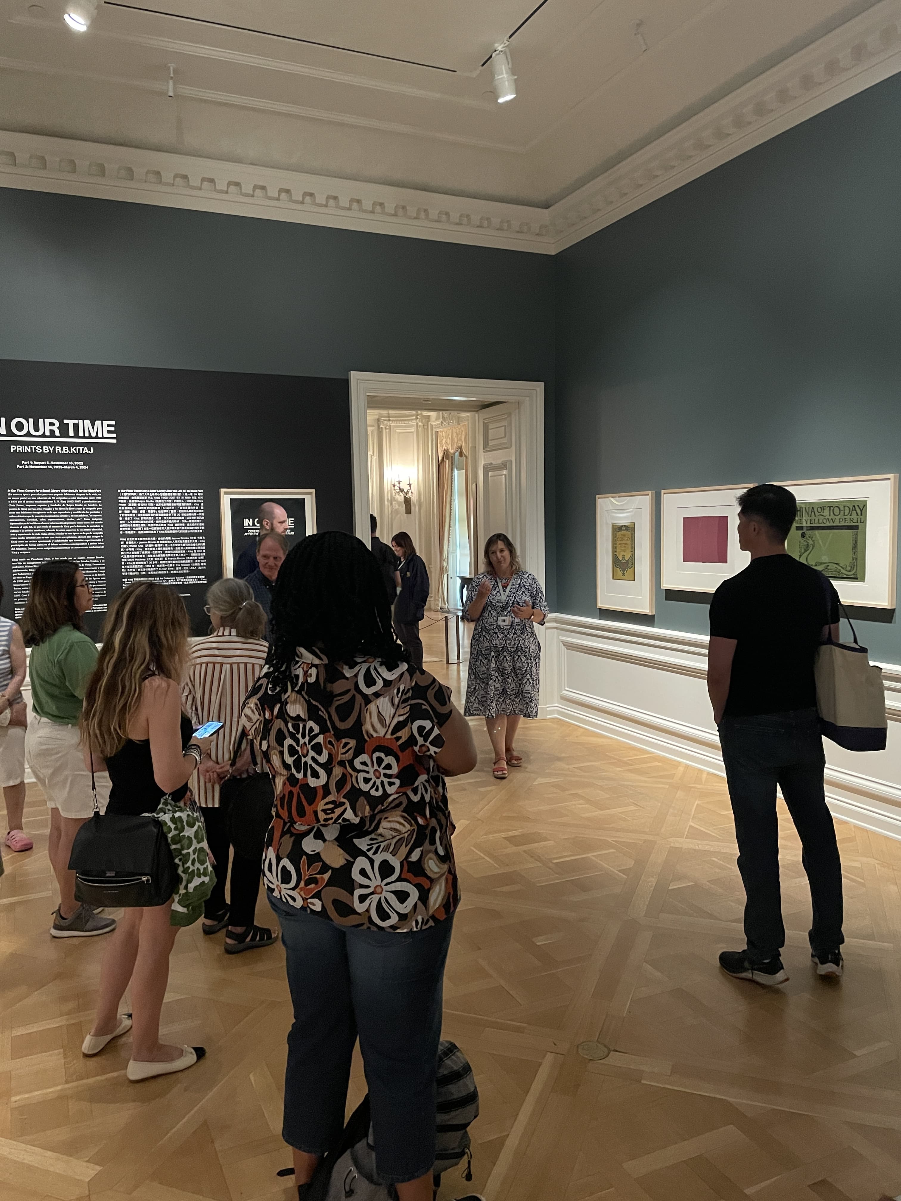 A docent talks to a group of people in an art gallery space.