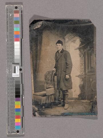 Portrait of unidentified young man in front of decorative studio backdrop