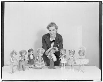 Woman posed with eight of the dolls