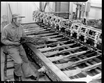 Man by milling machine that shapes wooden rifle stocks
