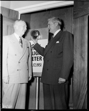 Two Edison executives standing next to installed "One Millionth Meter"