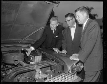 Men demonstrating the use of an early smog control device that vented engine exhaust back into air cleaner