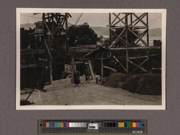 Huntington Library Construction: view showing part of the south wall of the Main Building looking north: two towers, two hoists, and a concrete mixer