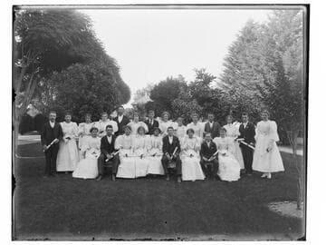 Young men and women with diplomas in park