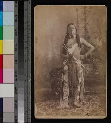 Studio portrait of a Pueblo Indian man holding arrows
