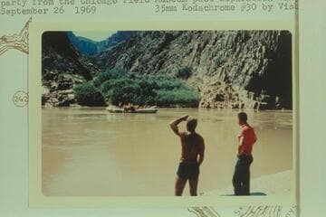 Crew of the float trip watch the baloney carrying the party from the Chicago Field Museum past Separation Canyon