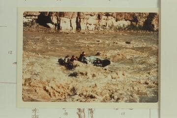 George Stewart's 10-man, with the 6 HP outboard drowned, swings down Coal Creek Rapid after clearing the hole at lower left. The difficulty was due to being off course to the right about 10-15 ft