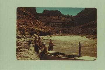 Frost party on the San Juan.  Second trip of 1947.  Left to right:  Sam Stone; Frank E. Frost (boatman); Claude Lortz is sitting on boat; Robert L. Gates (boatman).  Just below Government Rapid after running it