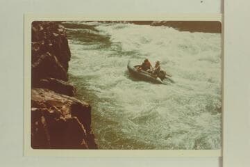 Outboard powered Zodiac boat climbing Requiem Rapid with Swanson at controls