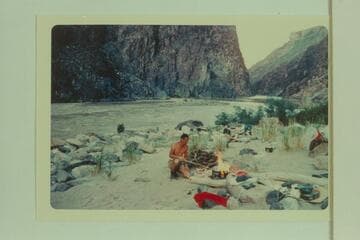 Camp at Travertine Creek with Travertine Rapid in background. The island is submerged by high water