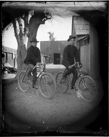 Two Chinese men on bicycles
