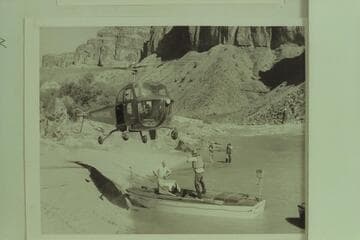 Red Carson piloting the helicopter over the "Esmeralda" at the head of Hance Rapid.  Joe Desloge and Ed Hudson are in the boat.  Marston and Taylor in the background