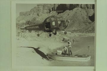 Red Carson piloting the helicopter as it hovers over the "Esmeralda" at the beach above Hance Rapid. Left to right: Joe Desloge and Ed Hudson. Marston at the edge of the beach in background