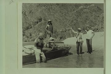 Ed Hudson determines not to continue on the water after cutting loose the "Esmeralda" at Mile 99.4, and he stayed on the beach with his son Edward.  Photos show a staged waving of farewells:  Taylor, Desloge, Forcier (standing), Hudsons