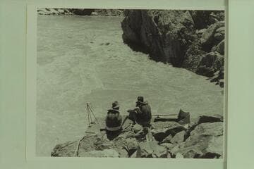 The cliff at the dog-leg at Mile 99.6 which trapped the "Esmeralda"  1950, June 17.  Edward Hudson [son] and Guy Forcier sit on shore.  Bright Angel gauge:  54,000 cfs