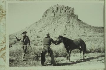 Wild Horse on a rope. The butte behind the horse is Mt. Akaba. The horse and man are south of Akaba looking north. Photo 500 of Expedition to So-Called "Canyon of the Little Horses."