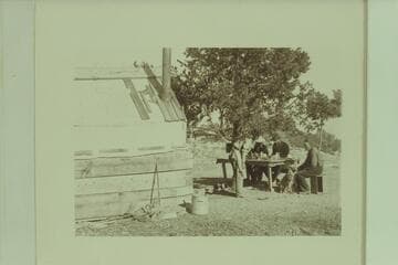 Bass Camp.  W. W. Bass at end of table with dog "Shep;" at his right is George Wharton James