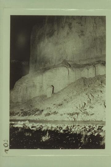 The cliff on the left bank at Nancoweap Rapid lighted by the drift fire.  Photo by available light [on photo reverse:  Cliffs lit up 1500 ft. high at Nancoweap drift fire]