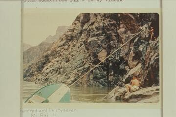 Salvage work on wrecked inboard-outboard at head of Gneiss Canyon Rapid. John Harrington below and Homer Morgan above