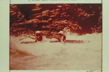 Bill Norris and Al Hard taking the heavy water in Vulcan Rapid riding a 2-seat kayak