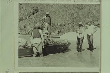 Ed Hudson determines not to continue on the water after cutting loose the "Esmeralda" at Mile 99.4, and he stayed on the beach with his son Edward.  Photos show a staged waving of farewells:  Taylor, Desloge, Forcier (standing), Hudsons