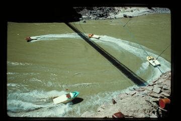 Four boats circle under bridge at Bright Angel Creek