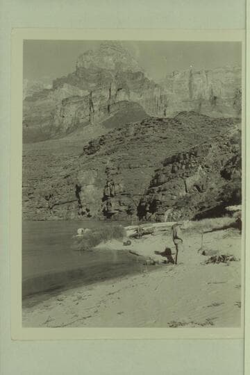 Camp at foot of Tanner Trail. The "Esmeralda II" is moored beyond the drift. Bestor Robinson watches the fire