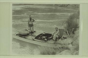 The "Esmeralda II" at camp at the foot of the Tanner Trail. Ed Hudson stands on the deck. Bestor Robinson sits at right