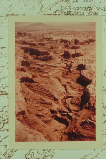 Northeasterly up Stevens Canyon. Mt. Hillers in the distance with the low cliffs at the left bank of Hall Creek below. The finger at upper right is shown on the map with an elevation of 5097
