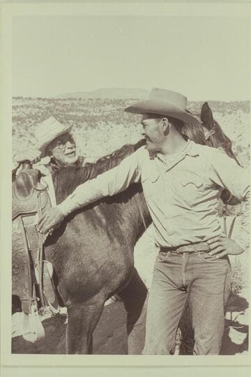 Masland talks over the finer points of horse-flesh with Bahe.  Navajo Mountain on the horizon