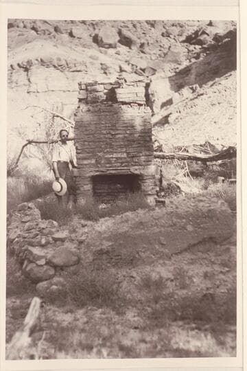 Charles Kelly at Cass Hite's fireplace, Tickaboo, Glen Canyon