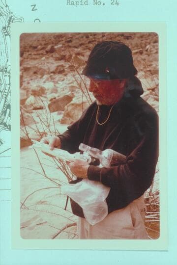 Dock Marston studies the record left by a Hatch party in a bottle near the Kolb inscription