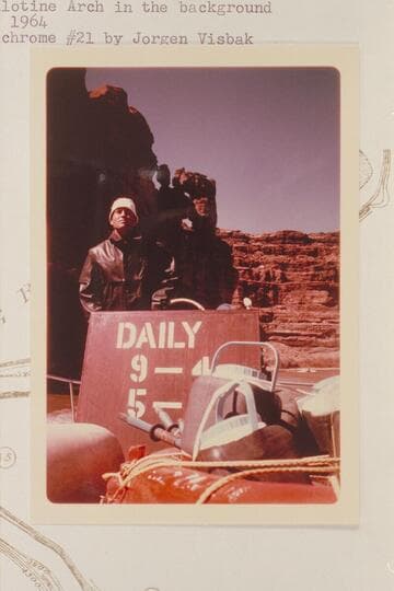 Tex McClatchy driving his jet boat below Monument Canyon with Guillotine Arch in the background