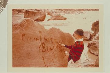 Dock Marston marking the inscription made by Harry McDonald of the Best Expedition after they locked a boat on the flat rock at upper left. Mile 204 1/2 in Rapid No. 16