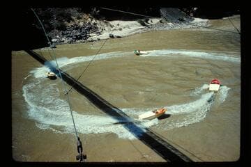 Four boats circling under Bright Angel Bridge
