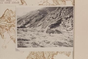 Serpentine Canyon.  Les Jones upset on rock above--pushed boat ahead to foot and pushed it by this rock.  Jones is on opposite side of rock.  9 AM